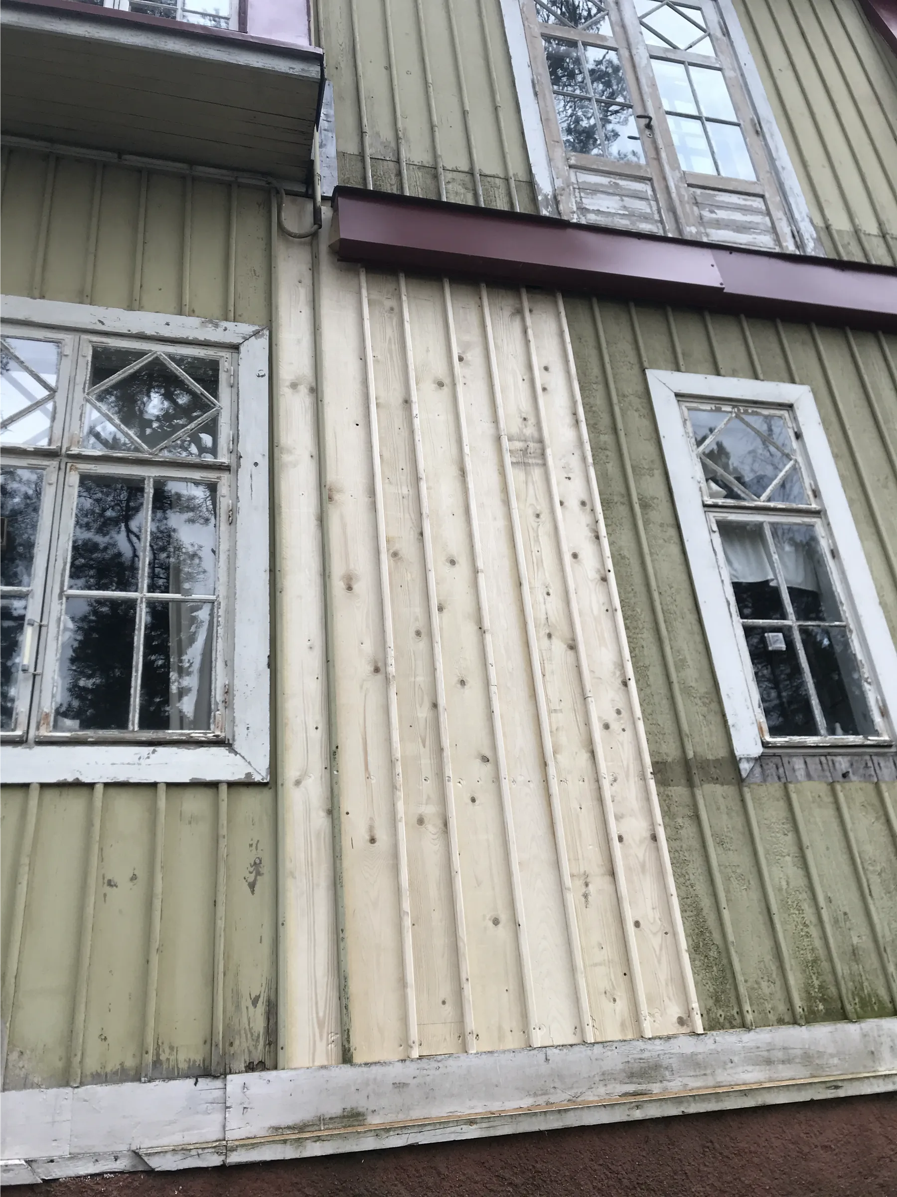 Vanha puutalo, jossa on ikkunat ja uusi puuverhous, valaistus on luonnollinen.